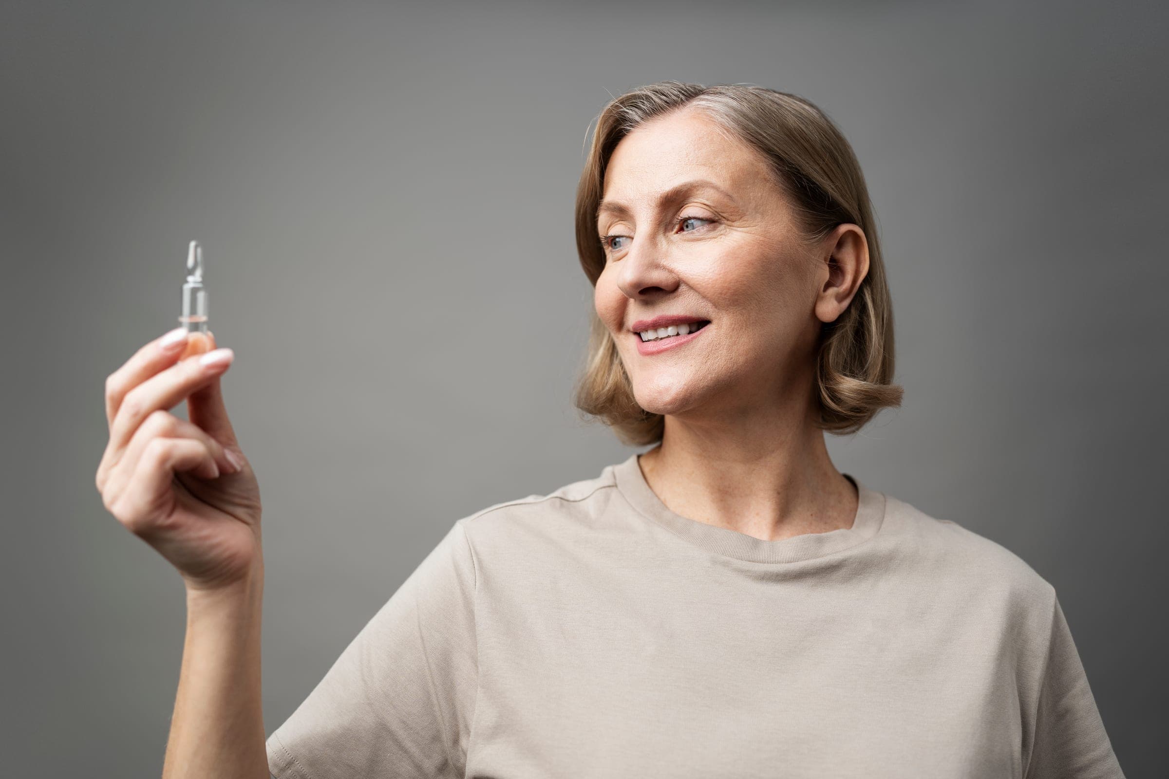 Smiling woman holding a vitamin vial